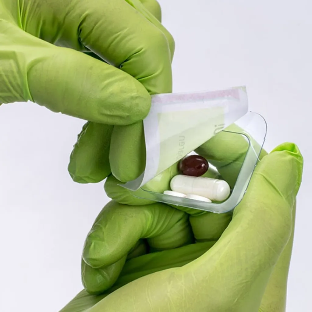 Hände öffnen ein versiegeltes Blister-Päckchen mit Tabletten